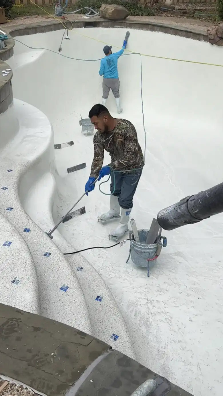 Aloha crew working on the curved entry steps of a freshly finished white pool