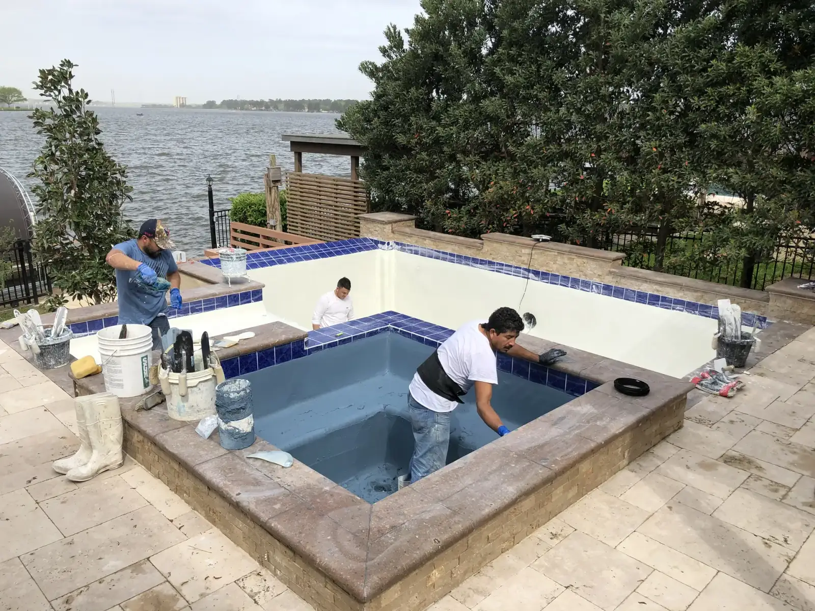 Aloha crew replastering a raised square spa beside a lake